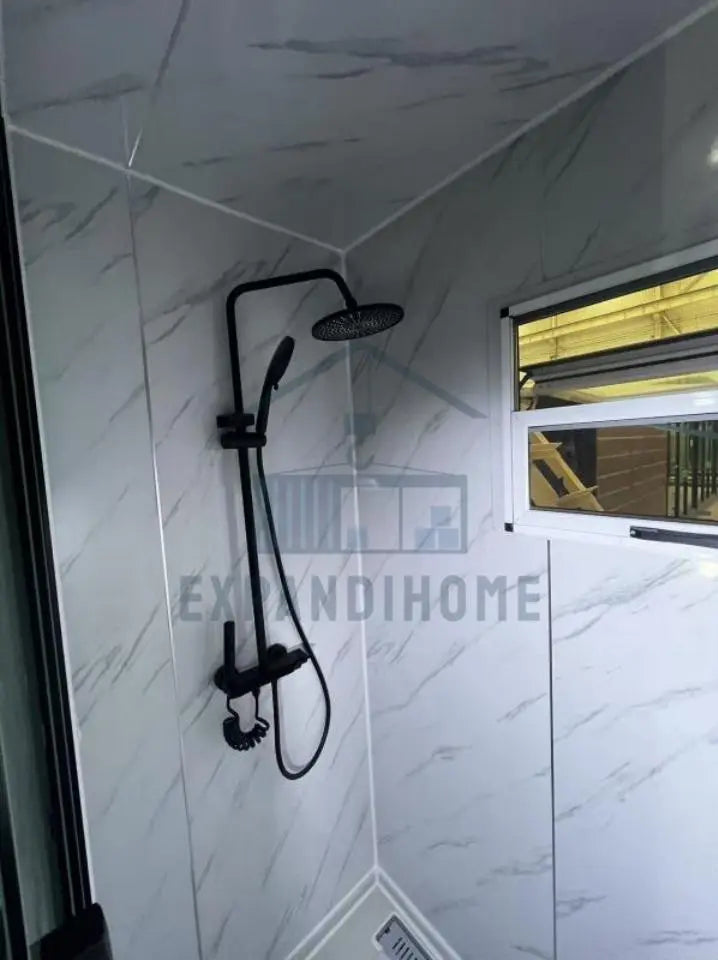 Shower setup with black fixtures in a tiled shower area, featuring a window.