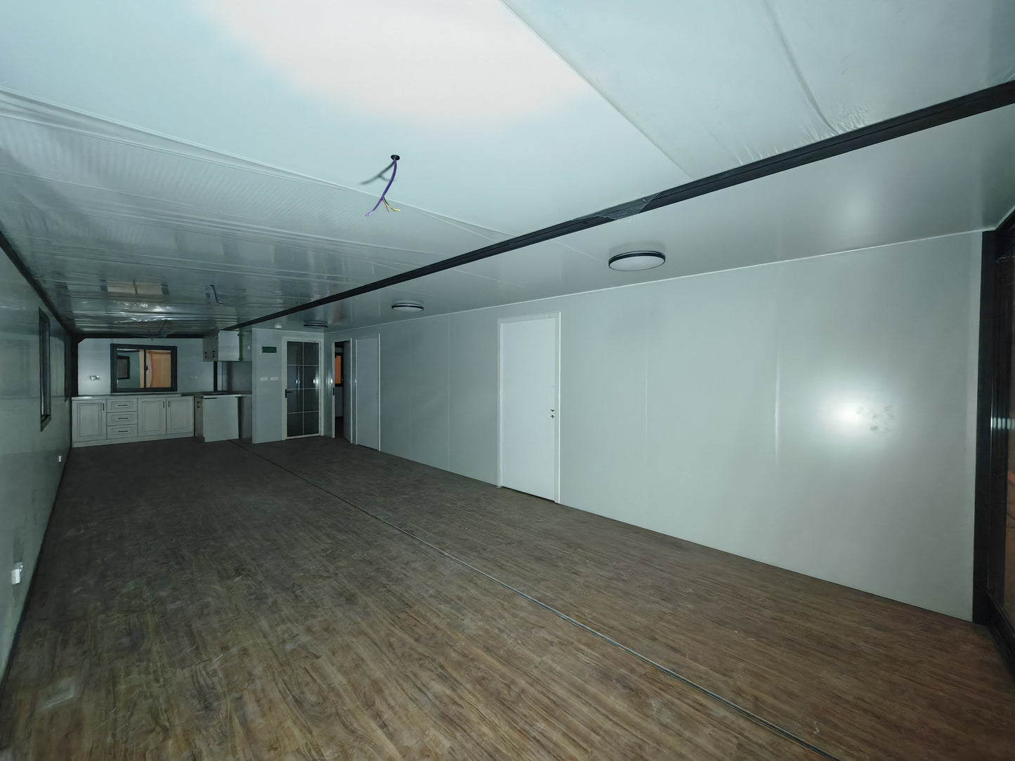 Empty room with wooden floor and white walls