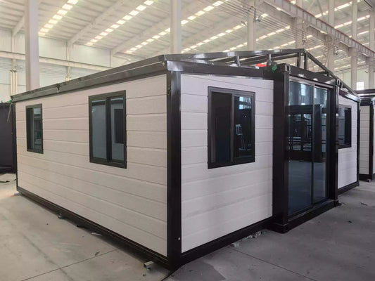 A 20ft expandable house with one bedroom, one bathroom, and one kitchen, featuring a white exterior with black windows and doors.