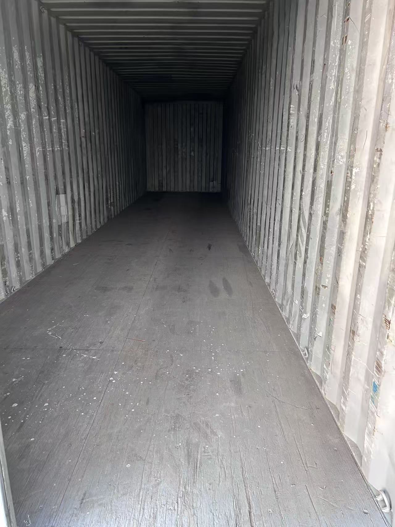 Empty interior of a shipping container with metal walls and floor.