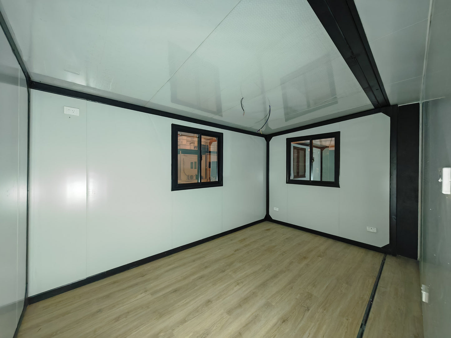 Small room with glass walls and windows, light wood floor, and white ceiling.