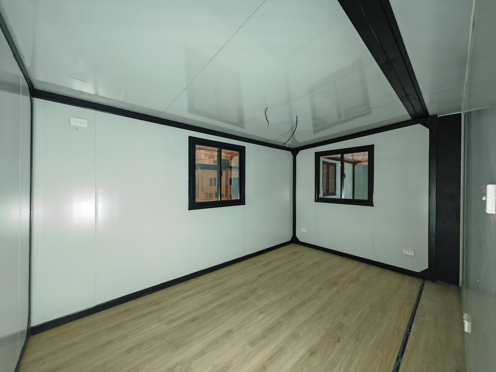 Small room with glass walls and windows, light wood floor, and white ceiling.
