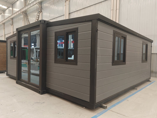 Modular building with gray exterior and black trim in a warehouse setting