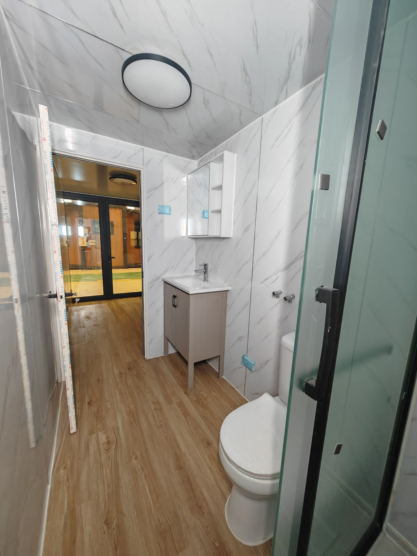 Modern bathroom with toilet, sink, and shower stall.