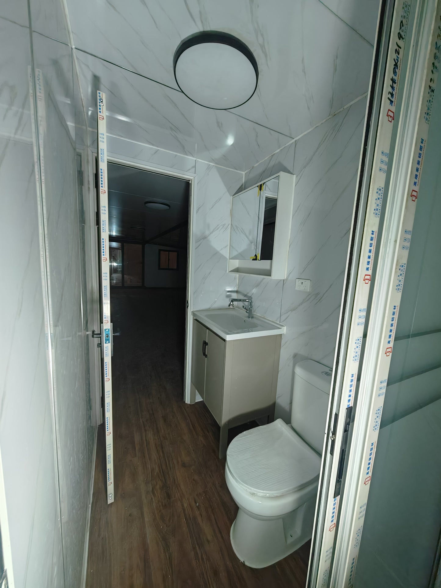 Bathroom with white tiles, toilet, and sink.