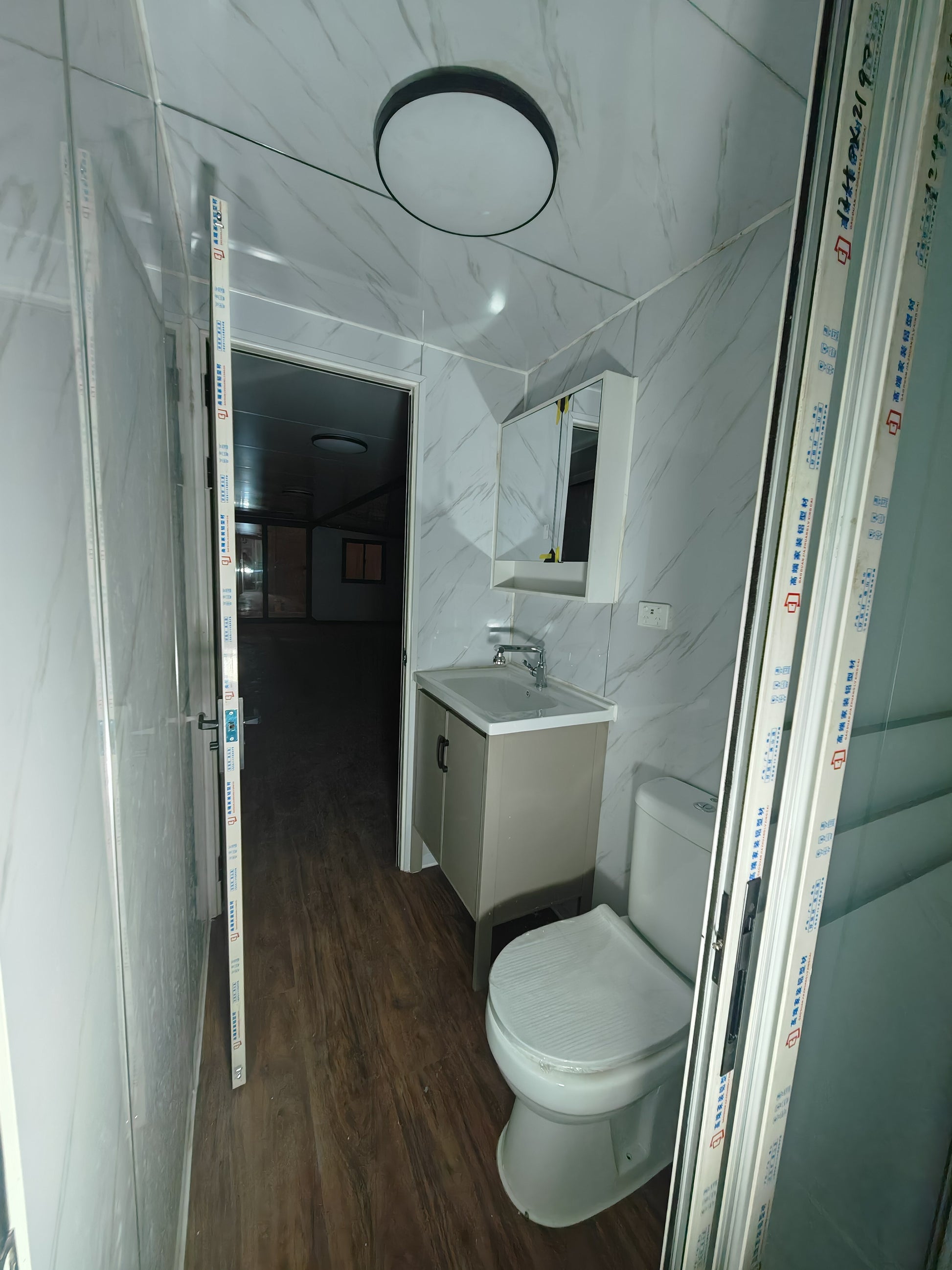 Bathroom with white tiles, toilet, and sink.