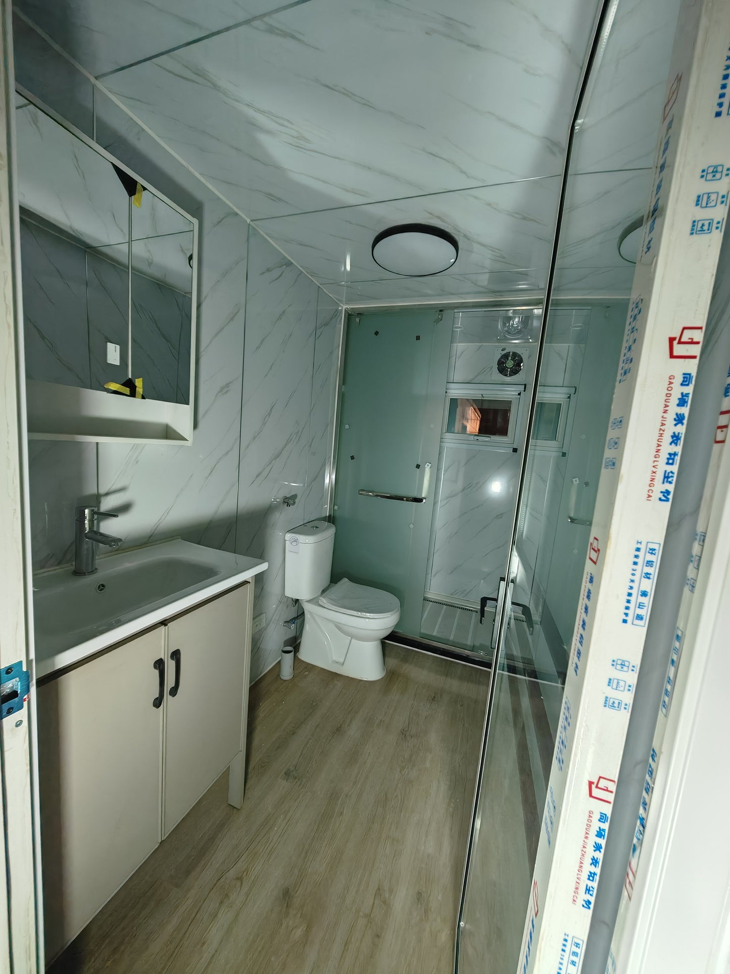 Bathroom with sink, toilet, and shower area, showing construction materials.