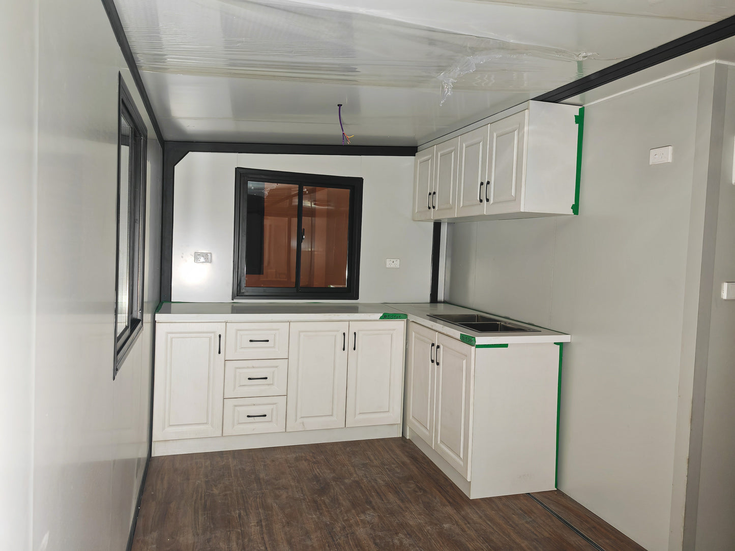 Modern kitchen with white cabinets and stainless steel appliances in a compact space.