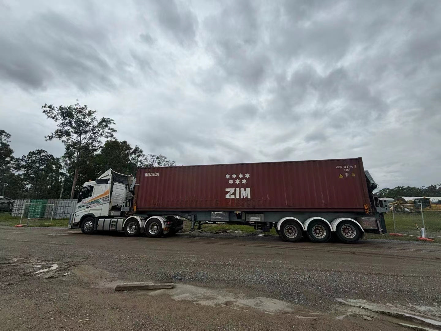 Truck with a ZIM container on a cloudy day