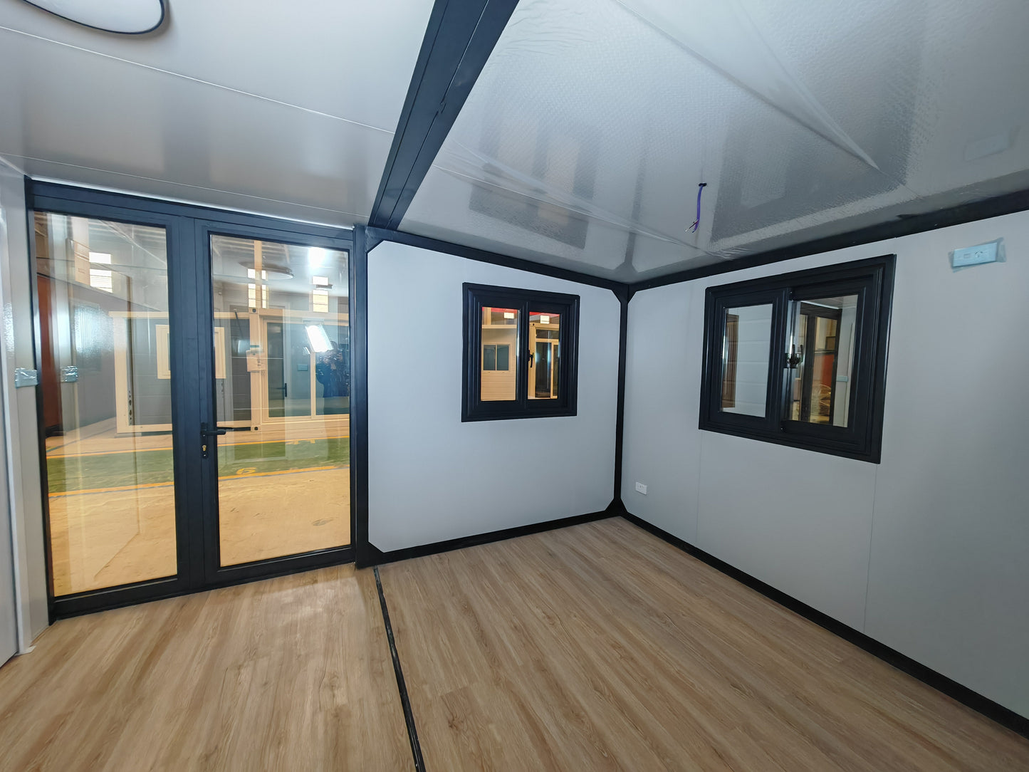 Modern office pod with glass walls and wooden flooring