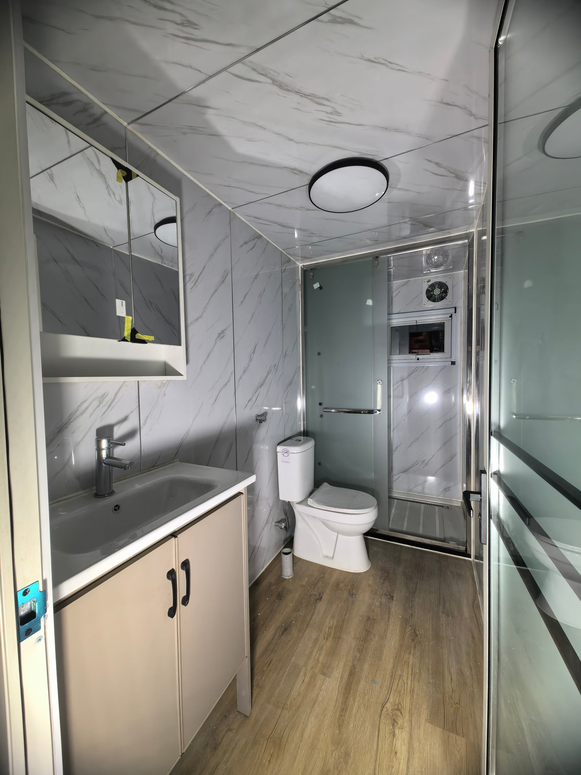 Modern bathroom with toilet, sink, and shower stall.