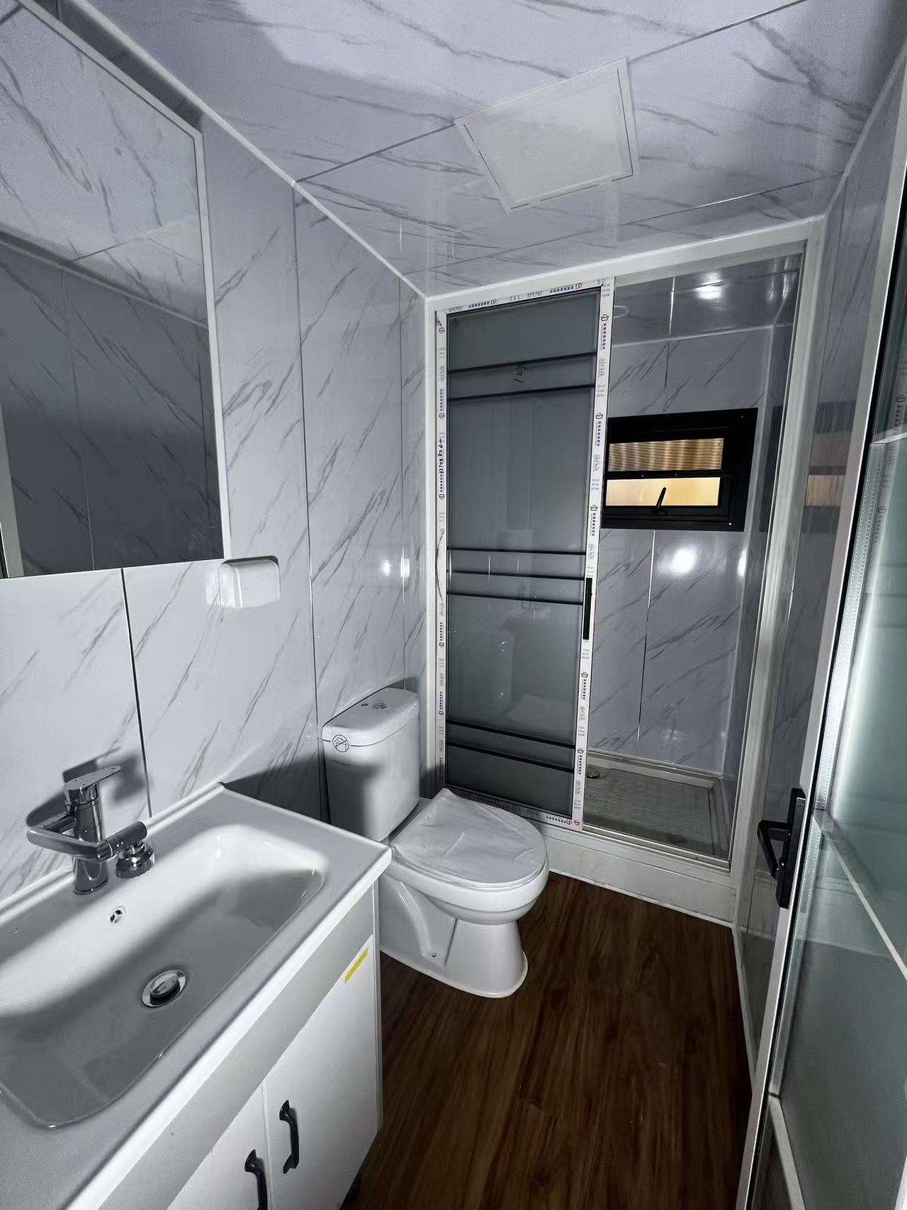 Modern bathroom with sink, toilet, and shower stall.