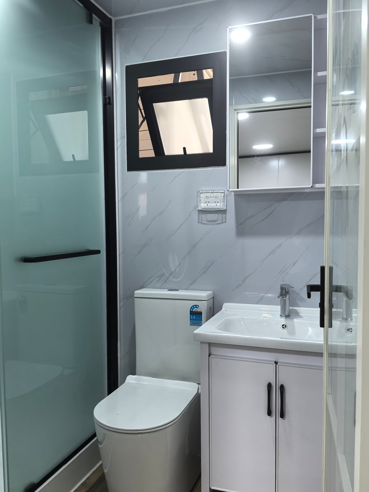 Modern bathroom with toilet, sink, and mirror