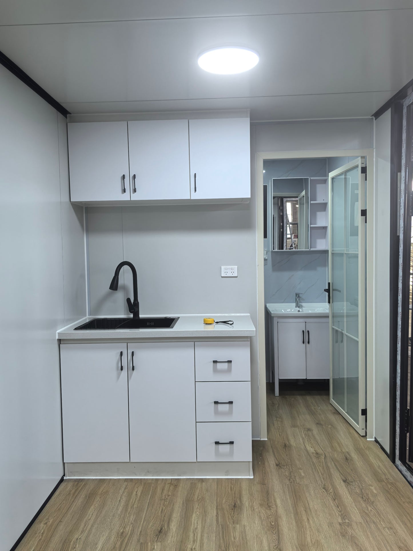 Modern kitchen with white cabinets, sink, and countertop.