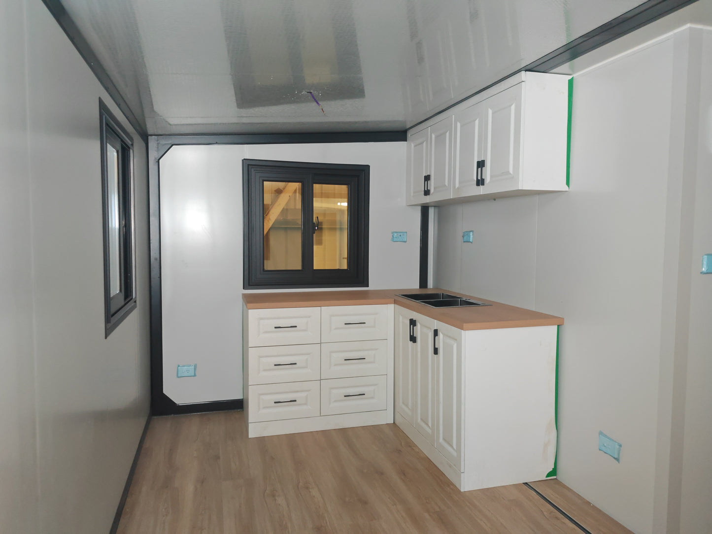 A  kitchen with white cabinets and wooden countertop