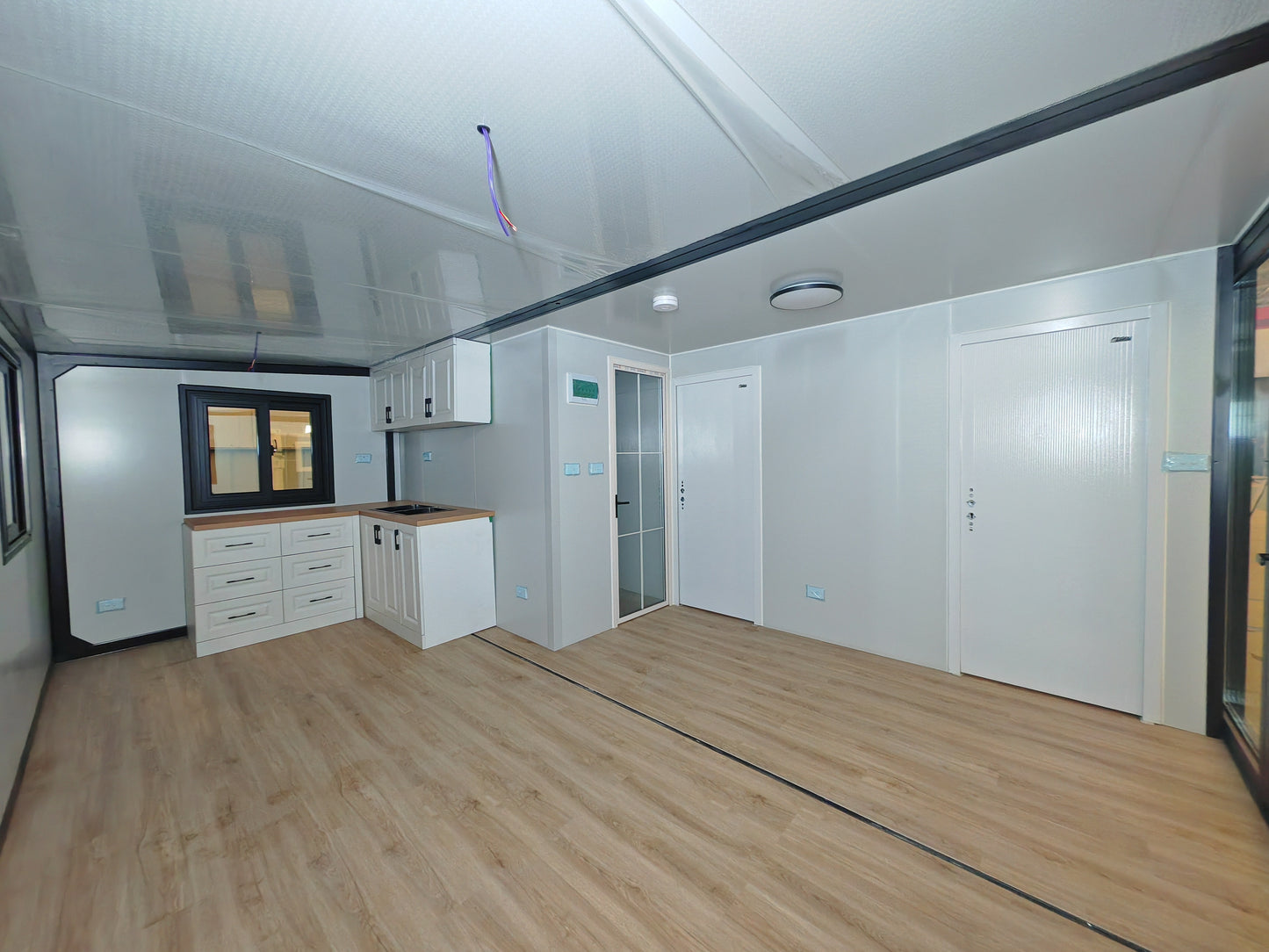Modern kitchen with white cabinets and wooden floor