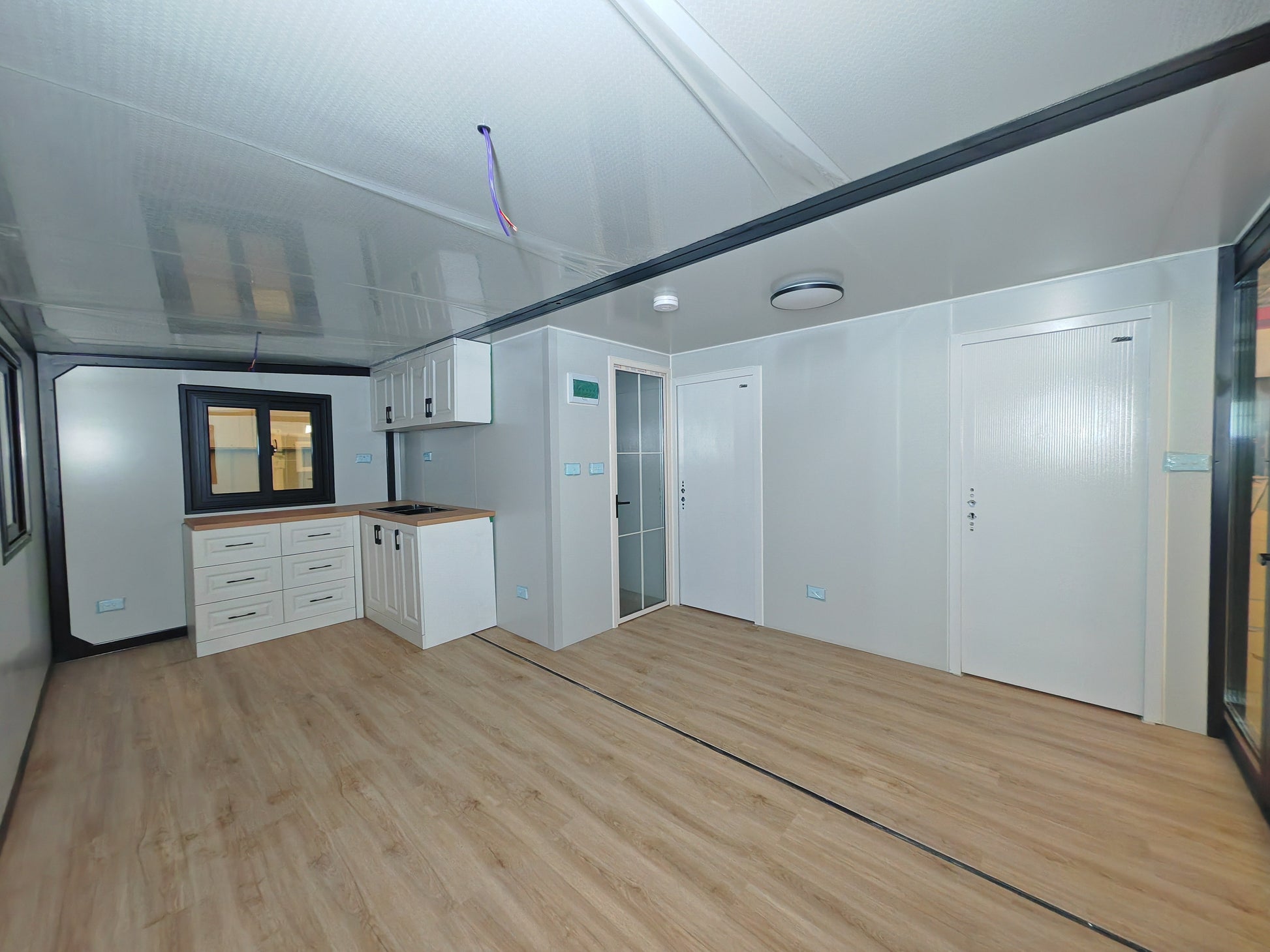 Modern kitchen with white cabinets and wooden floor