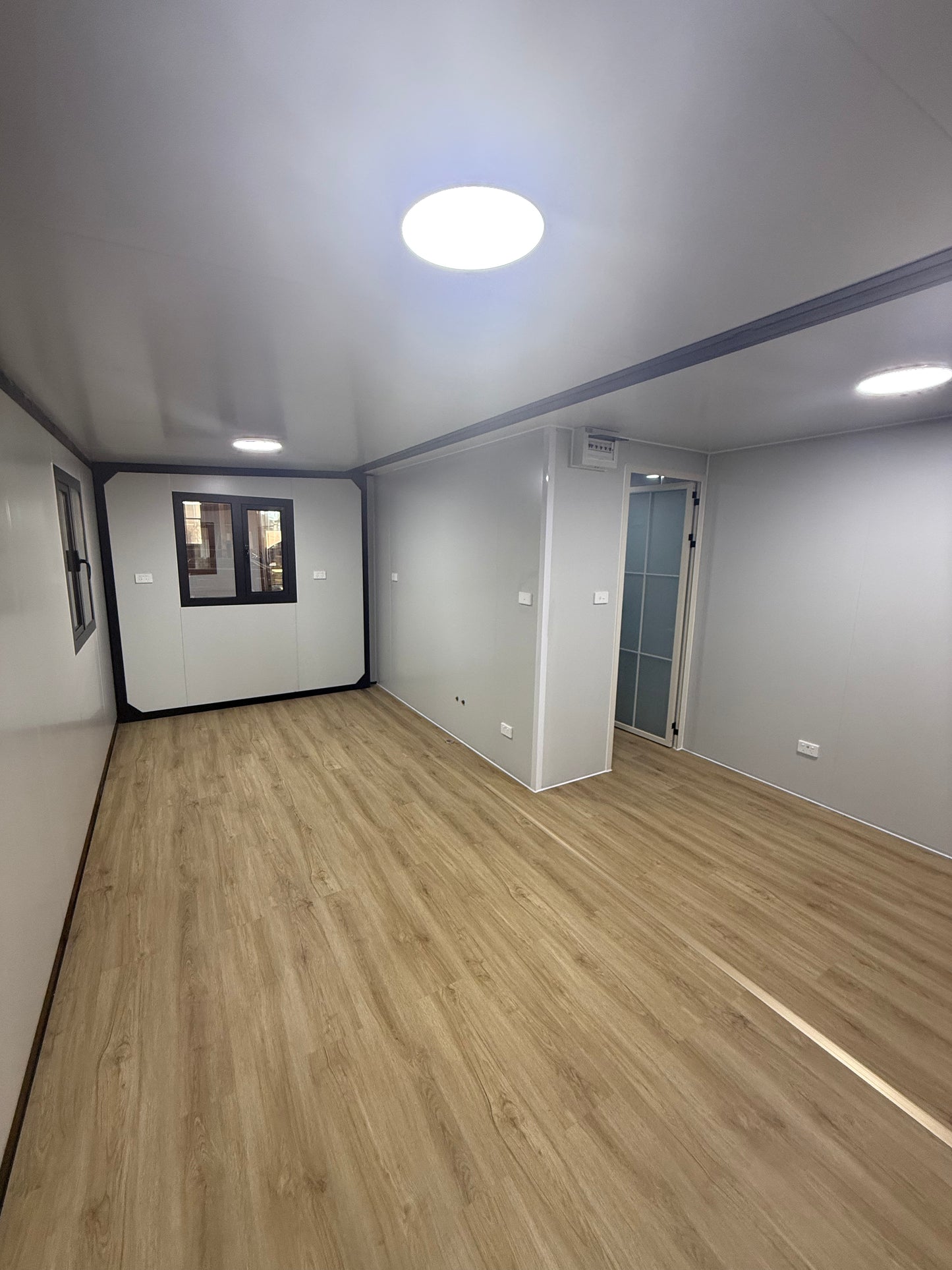Modern interior with wooden wall, ceiling light, and air conditioning unit.