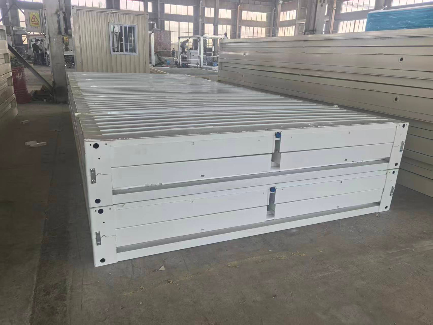 Large metal panel with slats on a concrete floor in an industrial setting