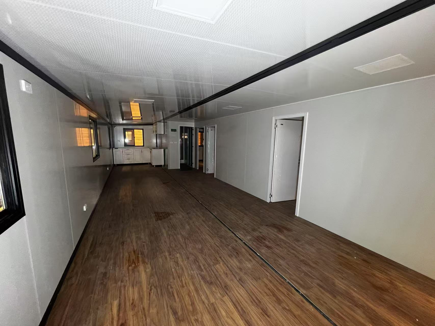 Long  living  room with wooden floor and white walls