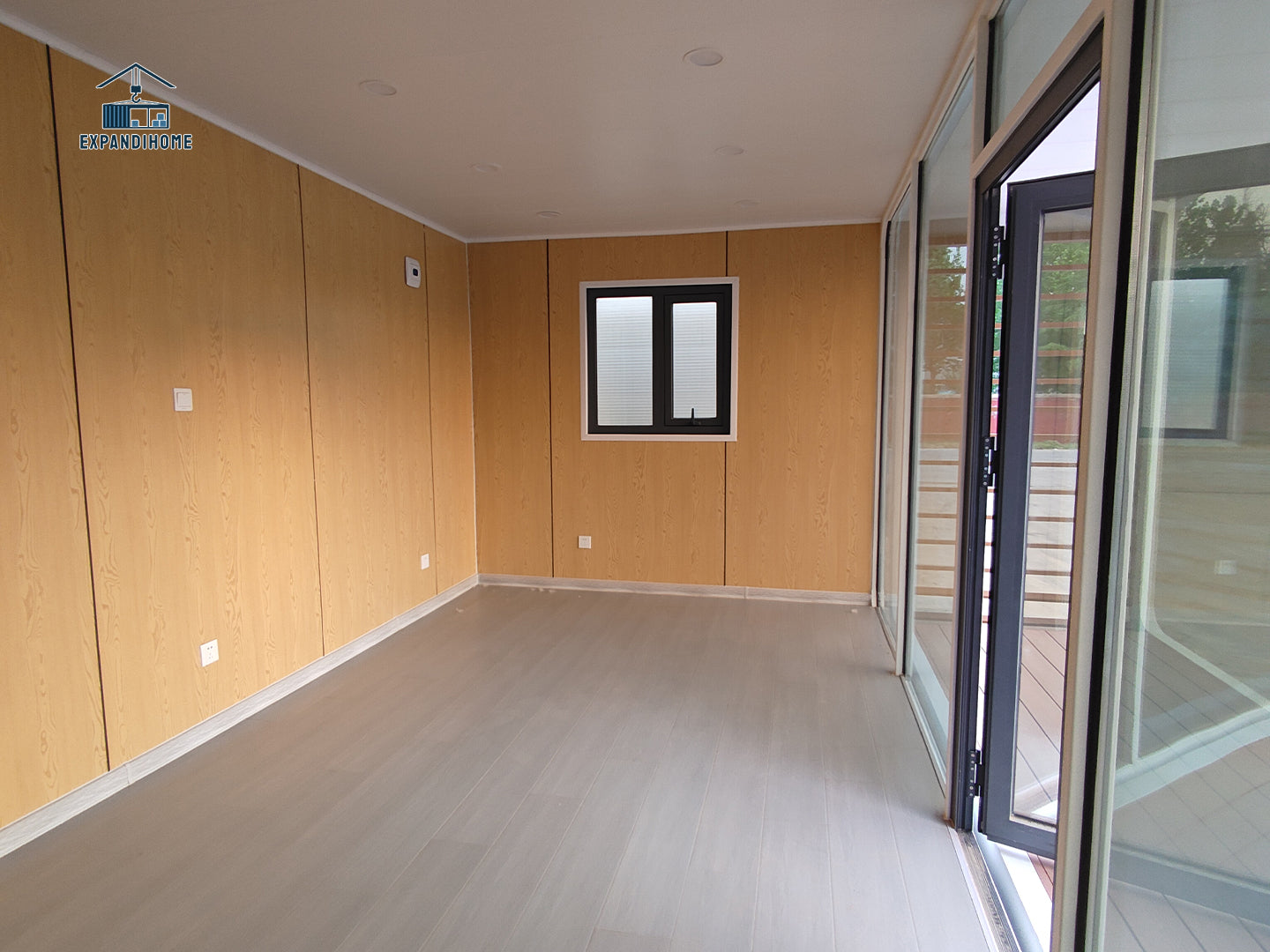Modern room with wooden walls, a window, and a glass door.